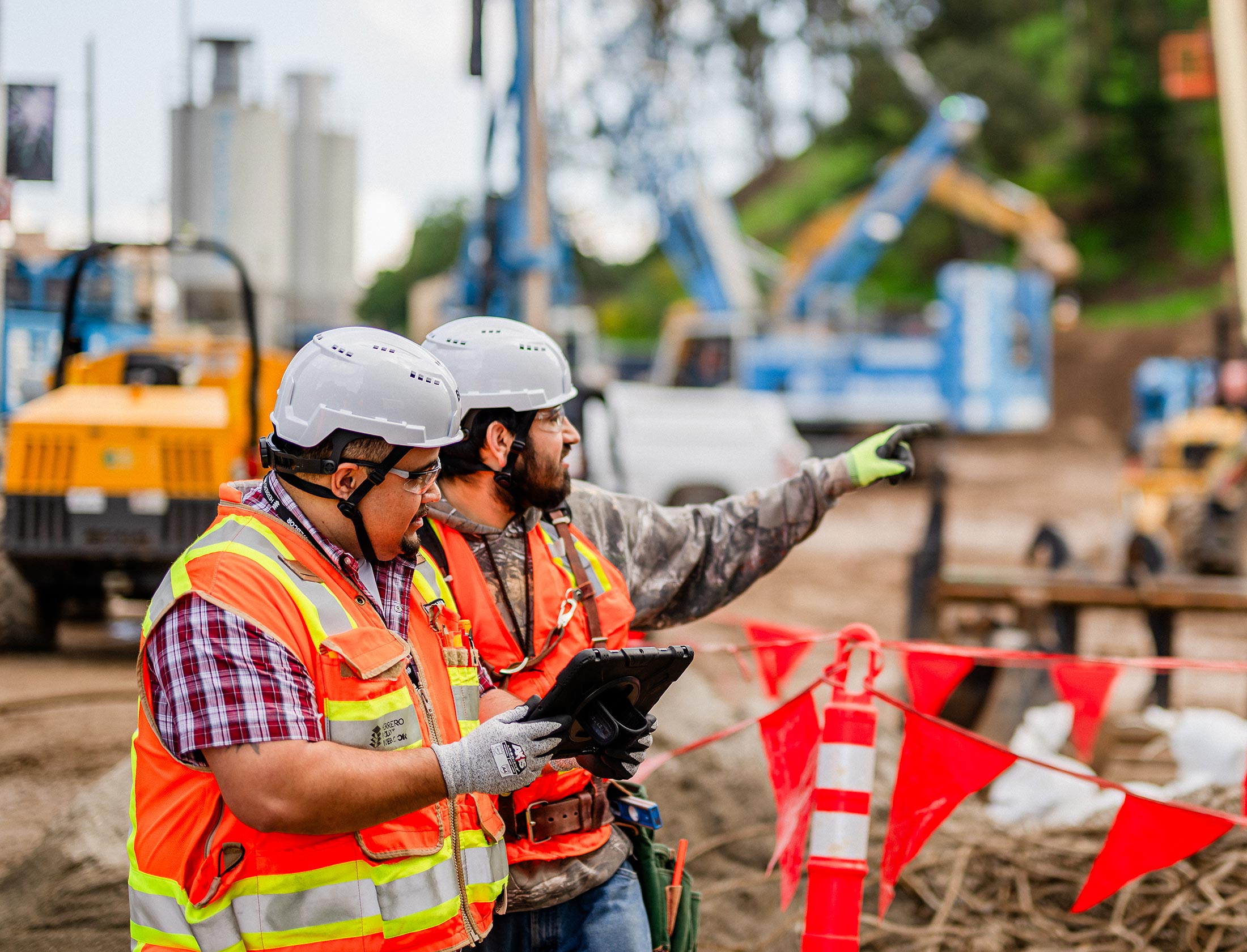 Two construction workers reviewing an active job site