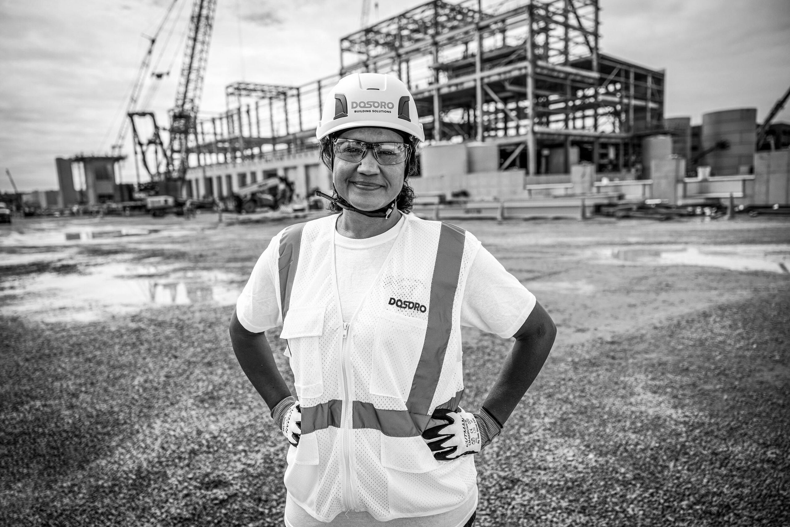 woman construction manager standing in front of active job site